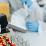 A laboratory scene featuring blood samples and a researcher using a pipette, ideal for medical research contexts.